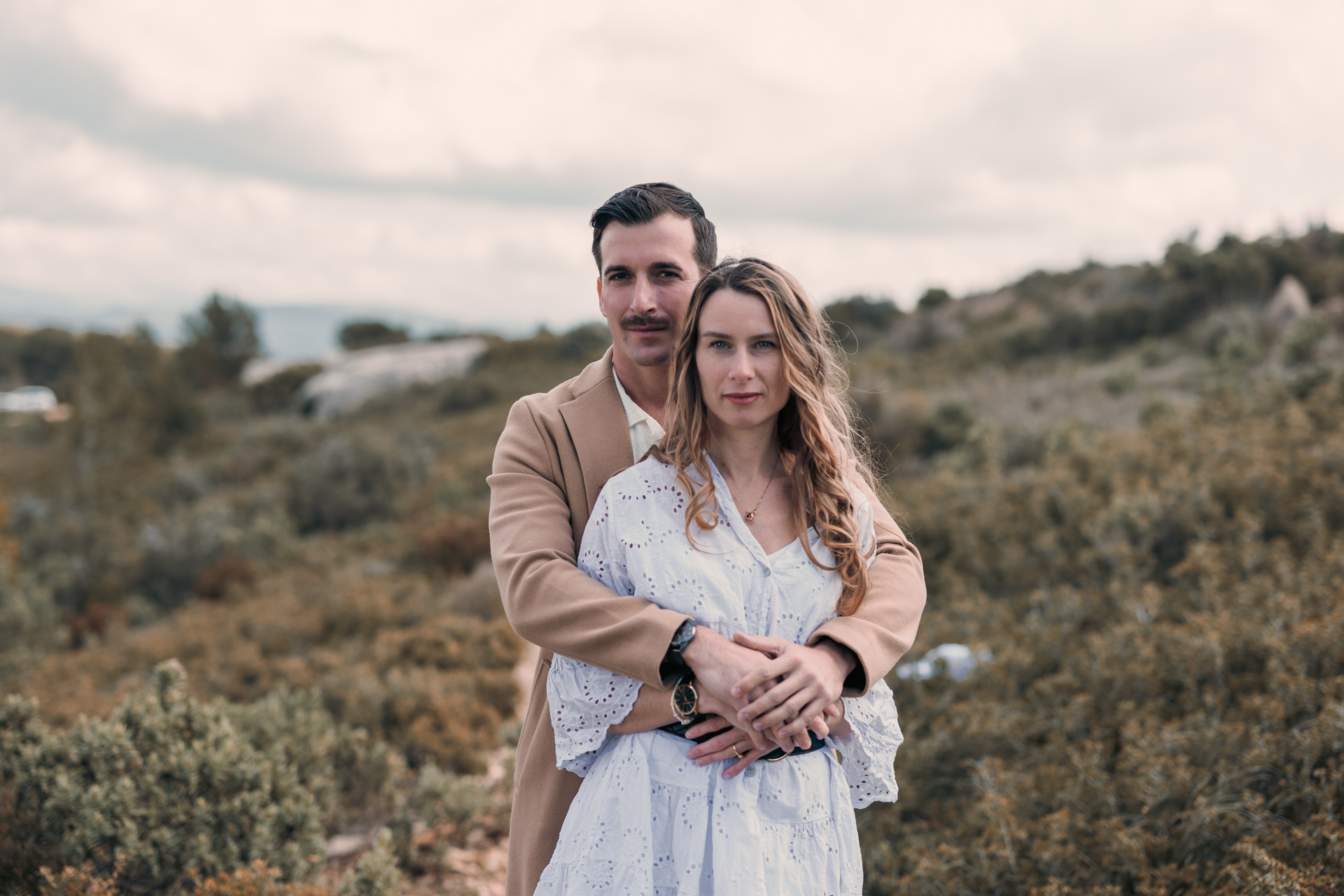 Couple de futurs mariés debout, dans la verdure, avec un ciel nuageux en fond – Photo de paysage lumineuse et naturelle