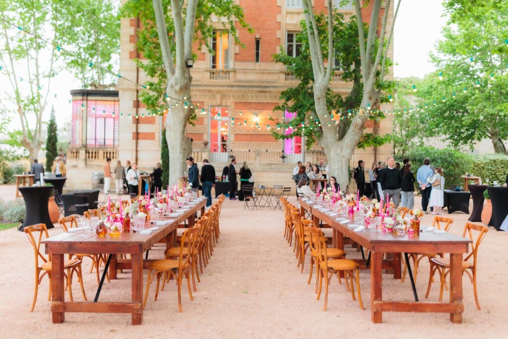 Mariage au Château la Beaumetane pendant le vin d'honneur, avec tables dressées et invités devant le château provençal